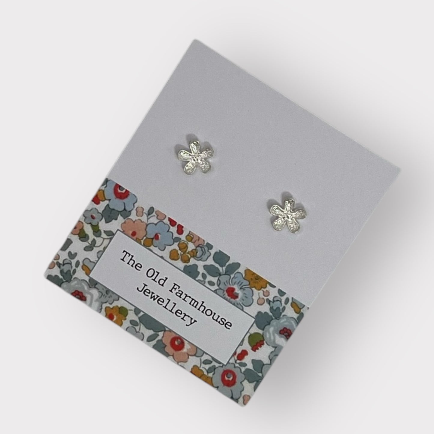 Pair of silver flower stud earrings with intricate detailing, a stylish and elegant accessory available for purchase from The Petal and Plant Company