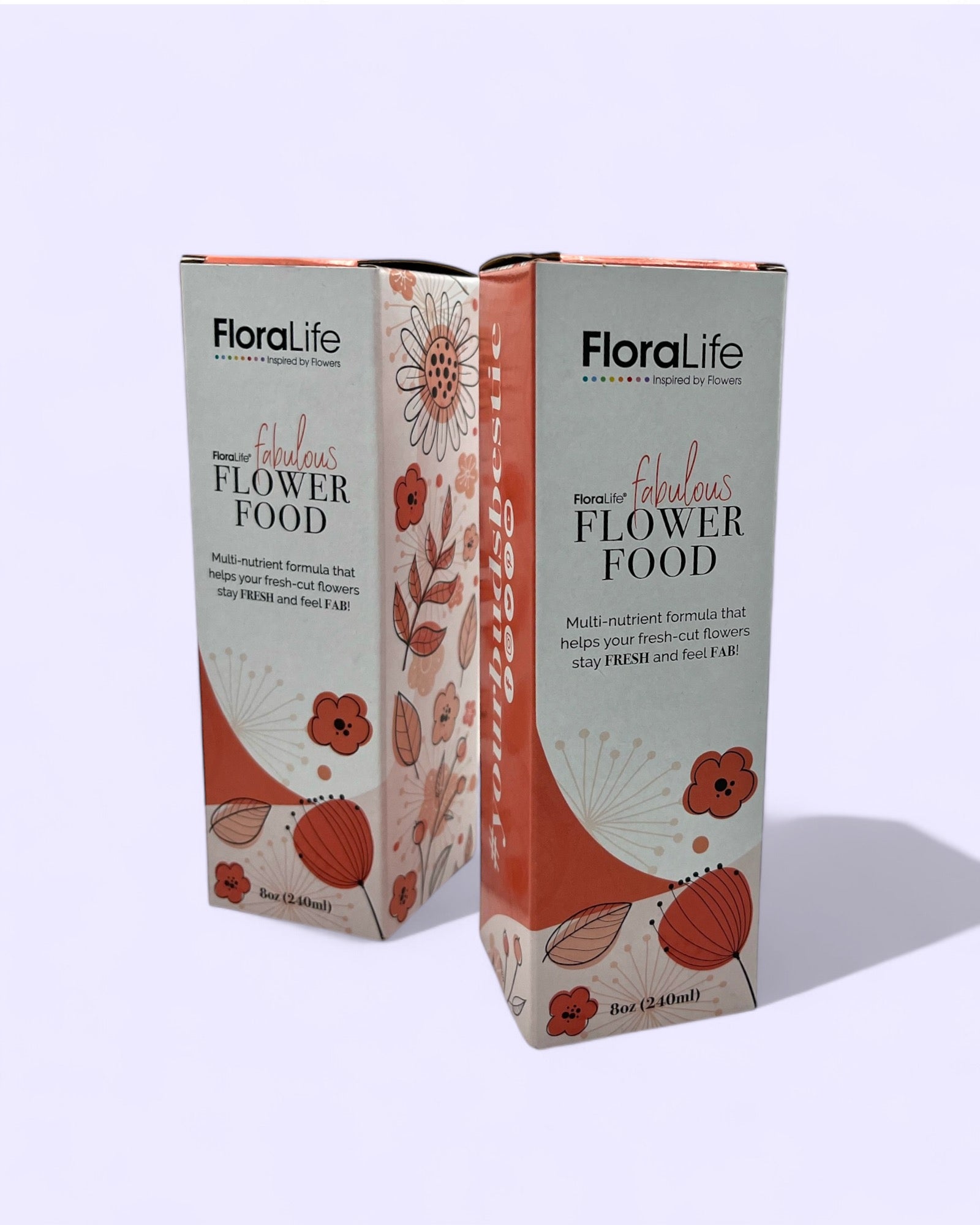 Two boxes of Floralife flower care food in white and orange/red packaging, displayed on a plain purple background, available for purchase from The Petal and Plant Company