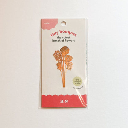 Tiny bouquet of brass roses beautifully arranged in their display packaging, a charming and unique gift available for purchase from The Petal and Plant Company.